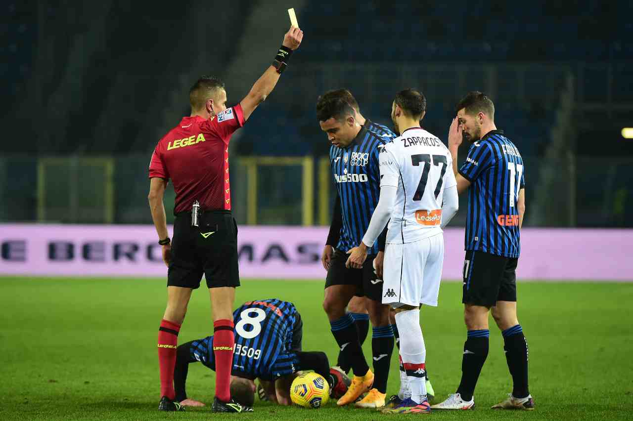 A sinistra: l'arbitro Livio Marinelli di Tivoli mostra il cartellino giallo a Davide Zappacosta del Genoa dopo il fallo su Gosens dell'Atalanta, 17 gennaio 2021 (foto di Pier Marco Tacca/Getty Images)