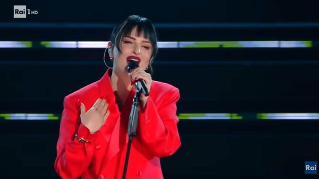 Arisa infiamma Sanremo con un tailleur rosso, ma tutti si concentrano su un dettaglio: “Dispositivo anti-Covid”